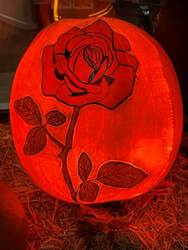 A pumpkin with a rose carved on it

AI-generated content may be incorrect.
